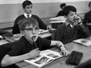 Scène dans une salle de classe avec un écolier attentif aux questions posées lors du tournage de l'émission «Jeux de société» réalisé par Jean-Pierre Gallo. 1966. Crédits : Georges Galmiche.